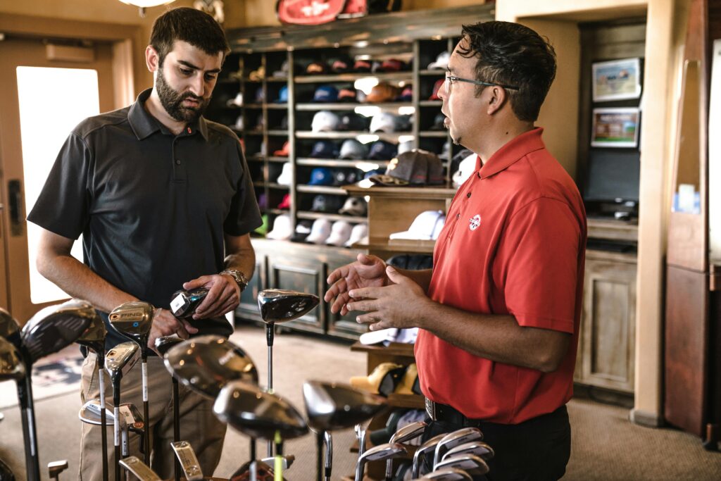 pexels-photo-1325735-1325735 Customer receiving expert advice from salesman on golf equipment in a store.